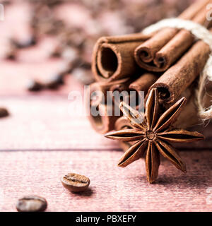 Bastoncini di cannella anice stella e chicchi di caffè da vicino il fuoco selettivo. Foto Stock