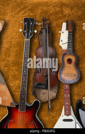 Strumento musicale - Vintage chitarra basso acustico, violino, balalaika su un peluche marrone dello sfondo. Foto Stock