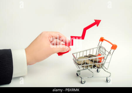 Il concetto di attrarre investimenti, aumentando il controllo media nel negozio. L imprenditore tiene con la mano il freccia in alto al di sopra del supermercato trollo Foto Stock