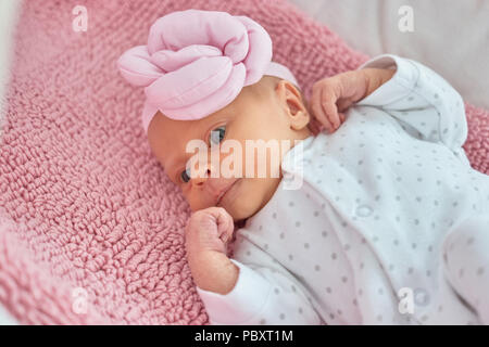 Close up ritratto di neonato ragazza. Fantasia rosa baby hat. Foto Stock