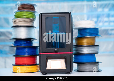 ABS e PLA filament accanto alla stampante 3D. Bobine di plastica Foto Stock