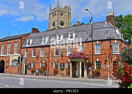 Il Castle Hotel è un palazzo del diciottesimo secolo coaching inn situato nel centro del mercato rurale comune di Devizes, Chiesa di Santa Maria è in background. Foto Stock