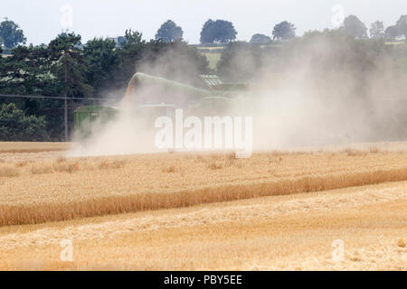 Earls Barton, Northamptonshire, Regno Unito. 26 Luglio, 2018. Un campo al di fuori di Earls Barton rd con un John Deere HillMaster S785i mietitrebbia facendo la maggior parte Foto Stock