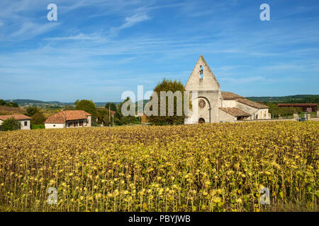 La pittoresca chiesetta nella frazione di Lieu Dit saint leger vicino a Tournon d'Agenais si vede al di là di un campo di girasoli di maturazione nelle zone rurali a Lot et Garonne campagna, Francia Foto Stock