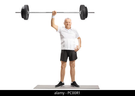 A piena lunghezza Ritratto di un uomo maturo in piedi su un tappeto di esercizio e il sollevamento di un barbell con una mano isolati su sfondo bianco Foto Stock