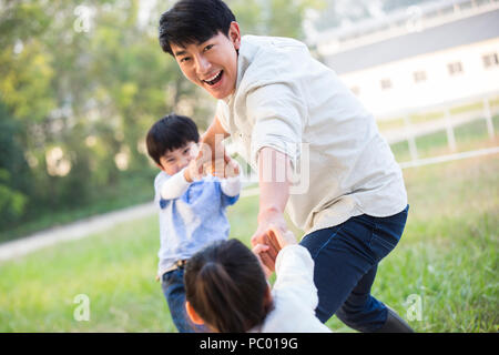 Allegro giovane famiglia cinese a giocare all'aperto Foto Stock