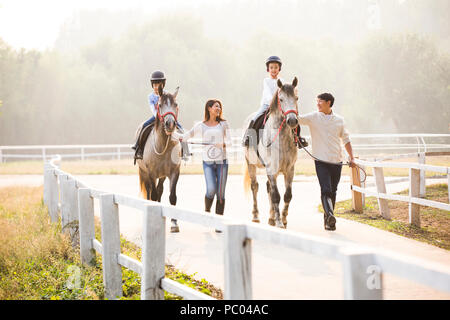Allegro giovane famiglia cinese di equitazione Foto Stock