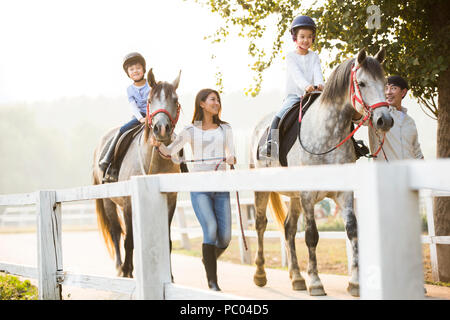 Allegro giovane famiglia cinese di equitazione Foto Stock