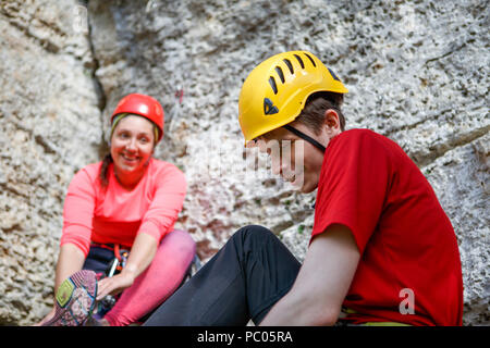Foto di sorridere sport uomo e donna scarpe di medicazione a cliff Foto Stock