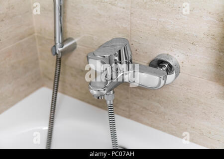 Doccia e vasca da bagno miscelatori in un bagno. Foto Stock