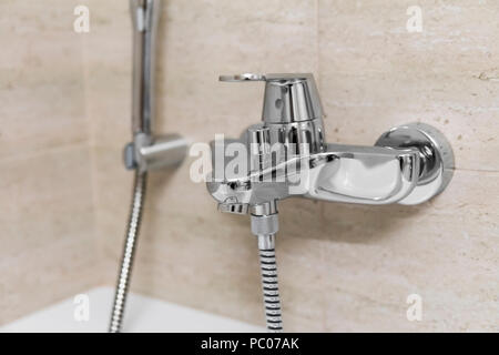 Doccia e vasca da bagno miscelatori in un bagno. Foto Stock