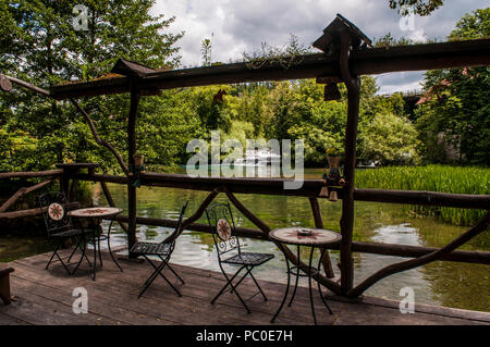 Croazia, Europa: tavoli e sedie di Rastoke, il centro storico del comune di Slunj, con la sua cascata cadere nel fiume Korana, Foto Stock