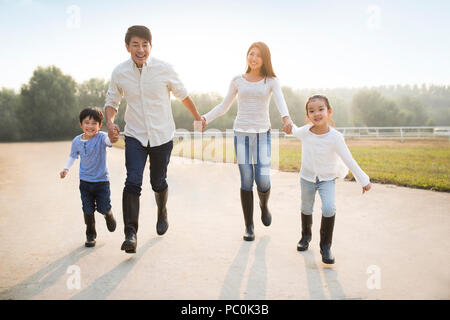 Allegro giovane famiglia cinese a giocare all'aperto Foto Stock