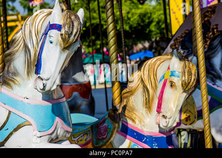 Cavallo di legno teste su Merry Go Round Foto Stock