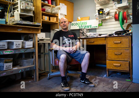 Craig Graffius, proprietario di EcoGlass cannucce, comporta per un ritratto nella sua bottega il 5 luglio Hood River, Oregon, Stati Uniti. Foto Stock