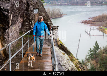 Una donna passeggiate con il suo cane su Beacon Rock in Columbia River Gorge. Foto Stock