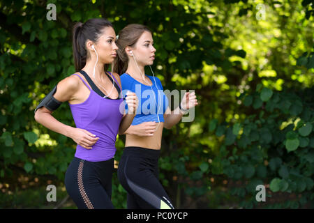 Due belle e attraenti ragazze fitness sono a fare jogging nel parco su una mattina di sole Foto Stock