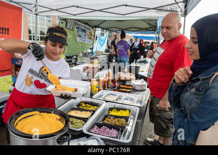 Dearborn, Michigan - Una donna serve una halal hot dog alla Smileys carne halal stand a un politico musulmano rally. La carne halal è preparata in conformità Foto Stock