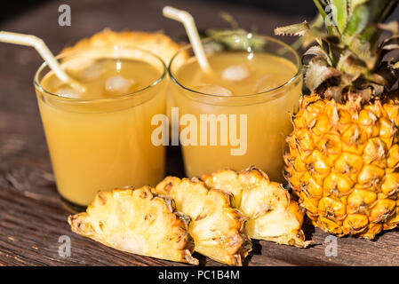 Succo di ananas e slice collocato su un tavolo di legno Foto Stock