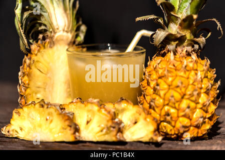 Succo di ananas e slice collocato su un tavolo di legno Foto Stock