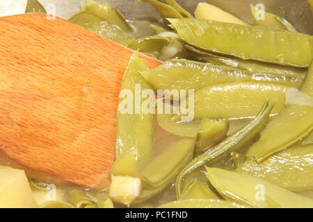 Baccelli di piselli e patate essendo realizzati in zuppa Foto Stock