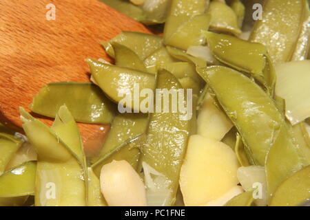 Baccelli di piselli e patate essendo realizzati in zuppa Foto Stock