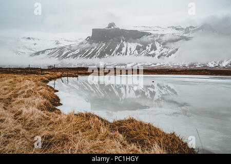 Islanda riflessione di montagna con ghiaccio e nuvole. Penisola Snaesfellnes Foto Stock