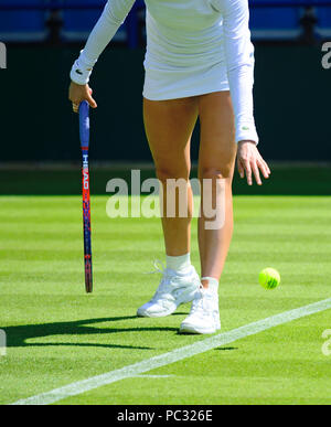 Anonimo femmina giocatore di tennis (Christina McHale) che consiste nel far rimbalzare la palla su una corte di erba prima di servire Foto Stock