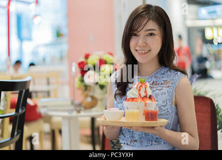 Donna che mantiene rasate di ghiaccio o di fragole fresche bingsu il sapore del latte Foto Stock