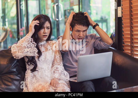 Ha sottolineato l uomo e la donna utilizzando laptop in un cafe Foto Stock