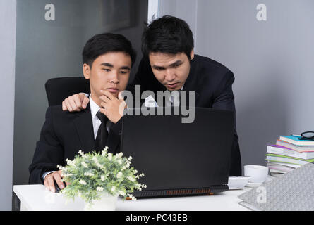 Due business uomo che utilizza un computer portatile e a discutere di progetto Foto Stock