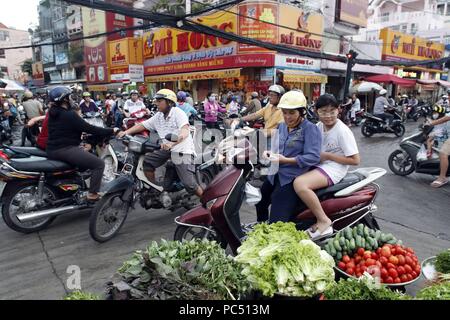 Mercato e le motociclette su strada caotica vita traffico. Ho Chi Minh City. Il Vietnam. | Utilizzo di tutto il mondo Foto Stock