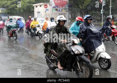 Forti piogge monsoniche. Popolo vietnamita di motociclette di guida sulla strada di Saigon. Ho Chi Minh City. Il Vietnam. | Utilizzo di tutto il mondo Foto Stock