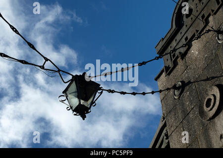 Appendere vecchia lanterna sulle catene del supporto a ponte sullo sfondo del cielo blu con nuvole Foto Stock