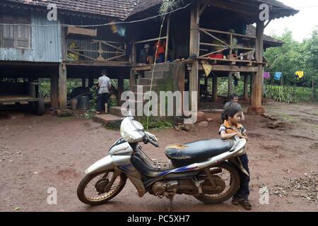 Jarai (Gia Rai) gruppo etnico. Moto e casa tradizionale. Kon Tum. Il Vietnam. | Utilizzo di tutto il mondo Foto Stock