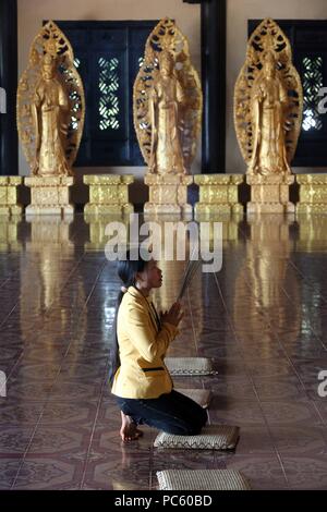 Linh una pagoda buddista. Donna in preghiera tenendo i bastoncini di incenso. Dalat. Il Vietnam. | Utilizzo di tutto il mondo Foto Stock