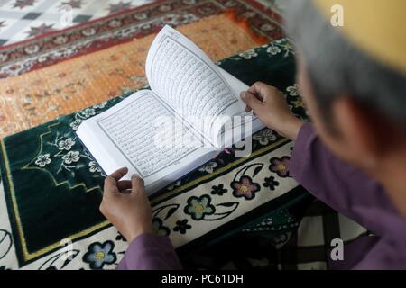Saigon Moschea centrale. Uomo musulmano la lettura di un Arabo Santo Corano o il Corano. Ho Chi Minh City. Il Vietnam. | Utilizzo di tutto il mondo Foto Stock
