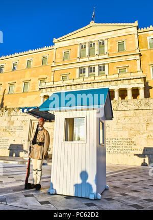 Un greco guardia presidenziale, Evzone, davanti al monumento del milite ignoto e il parlamento greco. Piazza Syntagma, Atene. Foto Stock