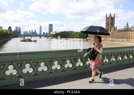 Londra REGNO UNITO. Il 31 luglio 2018. Regno Unito Meteo: un turista ripari dal sole sotto un ombrello sul Westminster Bridge come il clima caldo ritorna dopo una breve tregua e le temperature dello scambiatore di calore come l'ondata di caldo è previsto a riprendere il credito: amer ghazzal/Alamy Live News Foto Stock