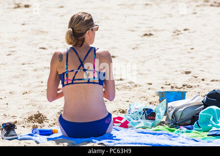 Bournemouth Dorset, Regno Unito. Il 31 luglio 2018. Regno Unito: meteo il sole torna e temperature aumento come spiaggia frequentatori in testa al mare per godere il caldo clima soleggiato. donna in bikini a prendere il sole sulla spiaggia. Credito: Carolyn Jenkins/Alamy Live News Foto Stock