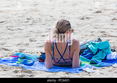 Bournemouth Dorset, Regno Unito. Il 31 luglio 2018. Regno Unito: meteo il sole torna e temperature aumento come spiaggia frequentatori in testa al mare per godere il caldo clima soleggiato. donna a prendere il sole sulla spiaggia. Credito: Carolyn Jenkins/Alamy Live News Foto Stock