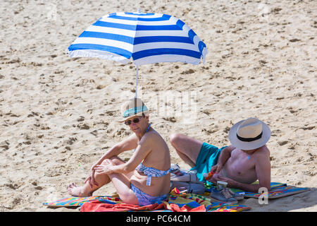 Bournemouth Dorset, Regno Unito. Il 31 luglio 2018. Regno Unito: meteo il sole torna e temperature aumento come spiaggia frequentatori in testa al mare per godere il caldo clima soleggiato. Coppia senior a prendere il sole sulla spiaggia. Credito: Carolyn Jenkins/Alamy Live News Foto Stock