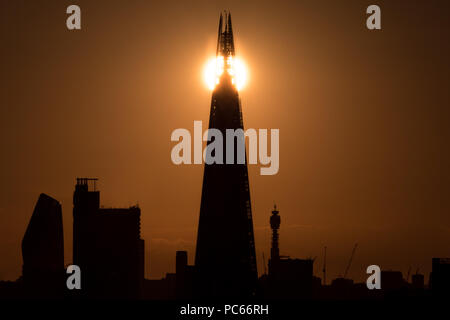 Londra, Regno Unito. 31 Luglio, 2018. Regno Unito Meteo: il sole al tramonto sopra la città è divisa dietro il grattacielo Shard. Credito: Guy Corbishley/Alamy Live News Foto Stock