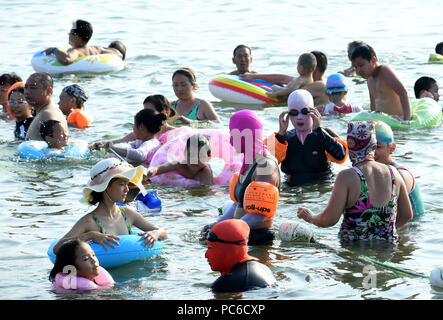 Qingdao, Cina Shandong. 1 agosto, 2018. Persone giocare con acqua su una spiaggia a Qingdao, Cina orientale della provincia di Shandong, e il Agosto 1, 2018. Credito: Li Ziheng/Xinhua/Alamy Live News Foto Stock