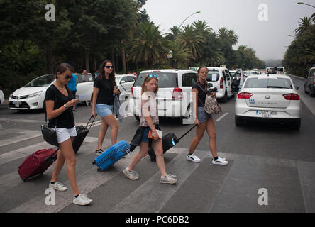 MALAGA, Spagna. 1 agosto, 2018. Un gruppo di turisti sono visti con le valigie come i tassisti bloccano la strada principale durante la dimostrazione.una protesta a sostegno del taxi driver' sciopero contro la concorrenza sleale da parte delle società di trasporto privato Uber Cabify e. Credito: Gesù Merida/SOPA Immagini/ZUMA filo/Alamy Live News Foto Stock