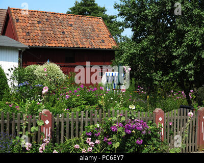 Prerow, Deutschland. 21 Luglio, 2018. Una sdraio sulla spiaggia si trova in un giardino cottage di una casa in legno in Prerow sulla Darss, registrato nel Luglio 2018 | Utilizzo di credito in tutto il mondo: dpa/Alamy Live News Foto Stock