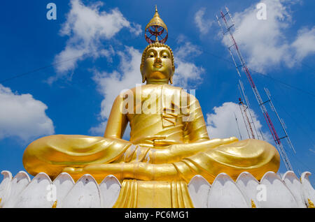 Buddha monumentale figura, dorata, con testa ombrello, sulla sommità di Tiger rock vicino a Krabi in Thailandia e radion antenna in background. Foto Stock