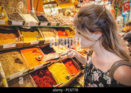 Bella donna profumi diversi tipi di spezie vendute in stallo in Egitto Bazaar a Eminonu,Istanbul, Turchia Foto Stock