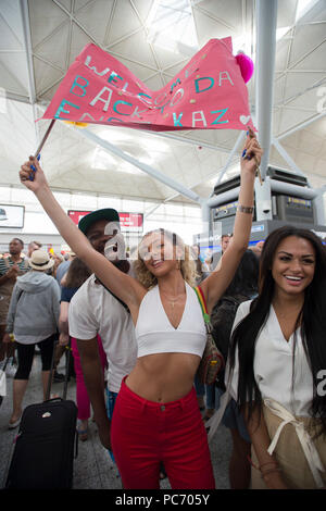 I sostenitori di amore isola contestant Kazimir Crossley tenere premuto su un banner all'Aeroporto di Stansted in Essex dopo la finale del reality show televisivo in cui Dani Dyer e Jack Fincham venivano incoronati vincitori 2018. Foto Stock