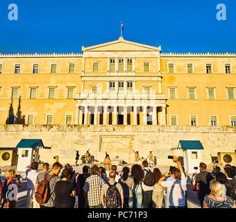 I turisti che frequentano il cambio della guardia della Evzones, soldati del Greco guardia presidenziale,il Palazzo Vecchio. Piazza Syntagma. Atene. Foto Stock